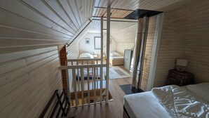 A room with wooden slatted walls, a bed with white bedding, a nightstand with a lamp, and a window with blinds. - Gite "Les Myrtilles (Laguiole)