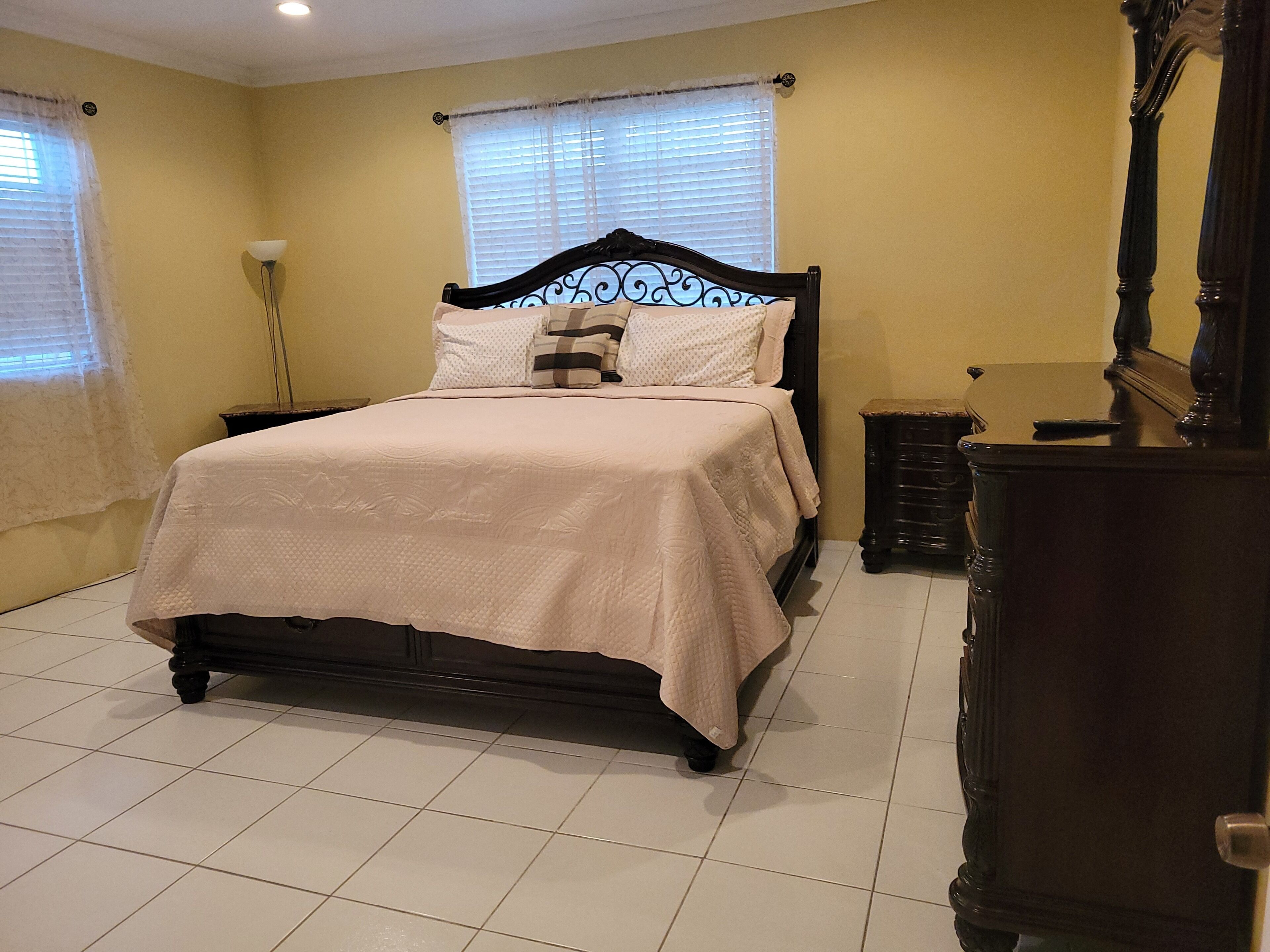 Une chambre à coucher avec un lit, une commode et une table de chevet.