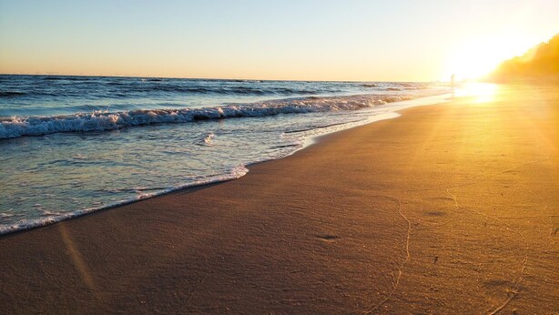 A beach with a sunset over the ocean. - Awesome apartment in Dobrzyca with WiFi (Dobrzyca)