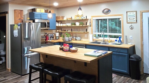 A kitchen with wooden ceiling, stainless steel appliances, a central island with stools, and a window with blinds. - Family lake escape! Huge deck/BBQ/fire pit. Bunk room. 5 min to boat ramp! Pets! (Cadiz)