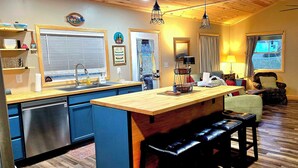 A kitchen with a wooden island, a dishwasher, and a dining area with a table and chairs. - Family lake escape! Huge deck/BBQ/fire pit. Bunk room. 5 min to boat ramp! Pets! (Cadiz)
