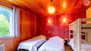 A room with two beds, a bunk bed, wooden walls, and a window with curtains. - L'oree DU Bois - Arole (VAL CENIS)