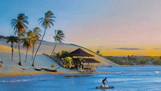 Eine Strandansicht mit einer Hütte, Palmen und einer Person auf einem Stand-Up-Paddleboard.