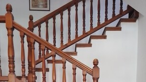 A wooden staircase with a basket of flowers on a table. - Eco Art Hotel (Peralejos de las Truchas)