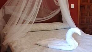 A bed with a white canopy and a swan-shaped pillow. - Eco Art Hotel (Peralejos de las Truchas)