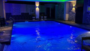A swimming pool with a tiled floor and a chair. - Vimpy Hotel Uyo (Uyo)