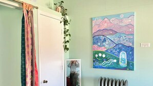 Ein Zimmer mit einer Tür, einem Heizkörper und einem farbenfrohen Bild an der Wand.