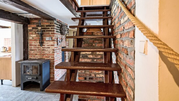 A wooden staircase with a rope handrail leading to a wooden door. - U sjezdovky by Interhome (Smržovka)