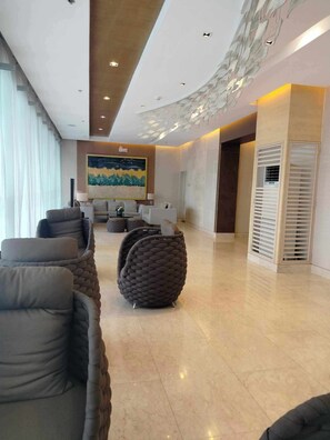 Relax in a stylish space with comfortable seating, a striking abstract painting, and a unique sculpture.