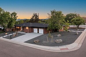 A single-story building with a garage, surrounded by landscaped gravel and trees. - Arvada Olde Town Oasis Accomodates 24 People (Arvada)