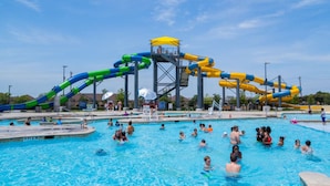 A swimming pool with multiple water slides and a lifeguard tower. - Arvada Olde Town Oasis Accomodates 24 People (Arvada)