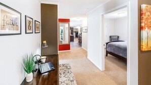 Una habitación de hotel con cama, escritorio con computadora portátil, silla y comedor.