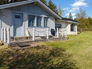 A single-story building with a porch, a small deck, and a covered seating area.