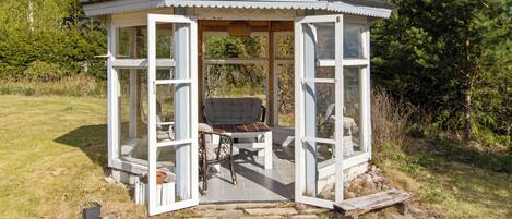 A gazebo with a hexagonal roof, open sides, and a bench inside.