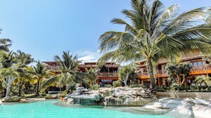 Un resort con piscina, palmeras y una cascada.