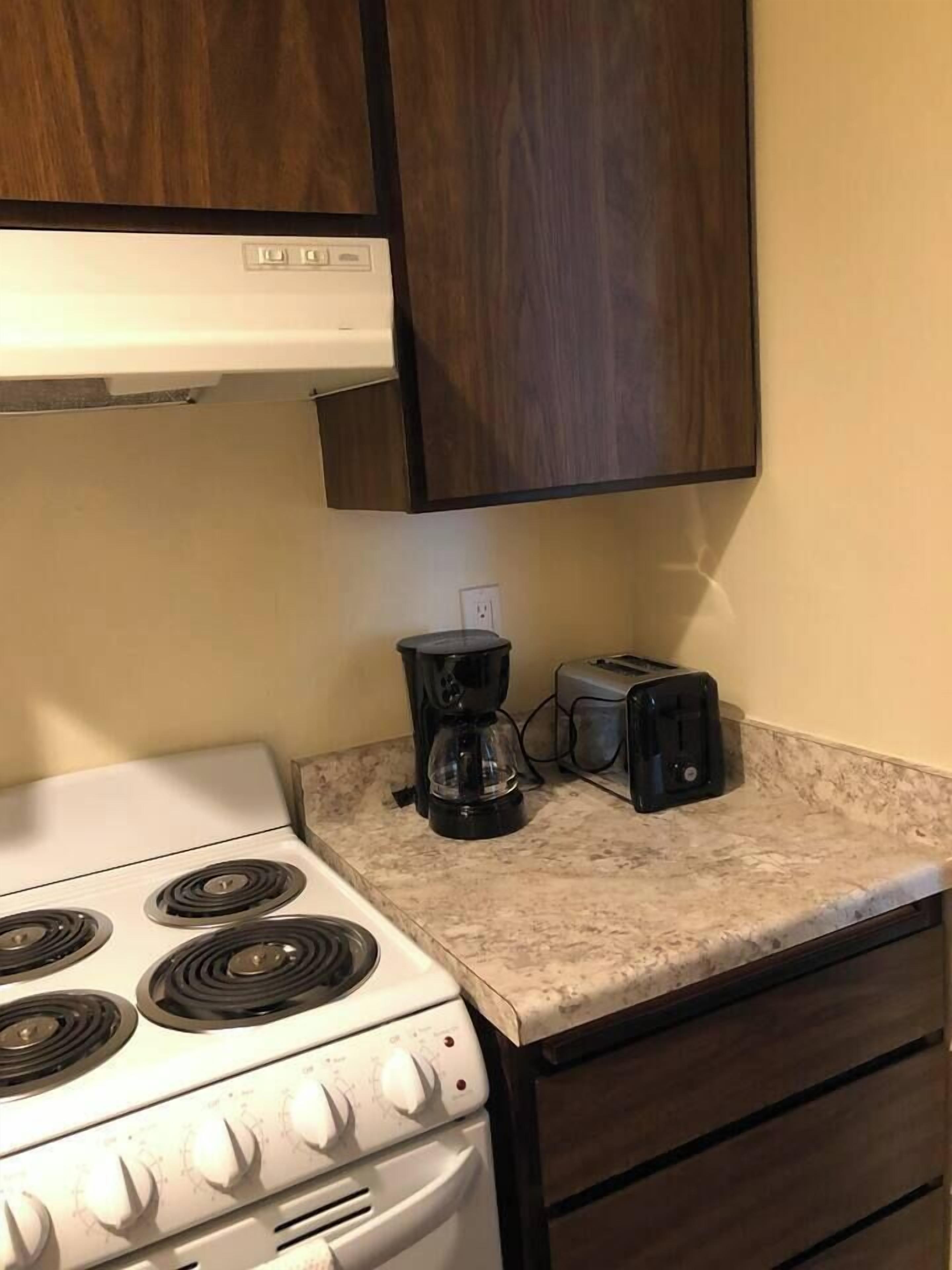 Eine Küche mit einem weißen Herd, einer Kaffeemaschine und einem Toaster auf der Arbeitsfläche.