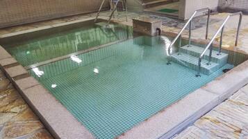 Una piscina interior con agua cristalina, paredes y suelo de baldosas.