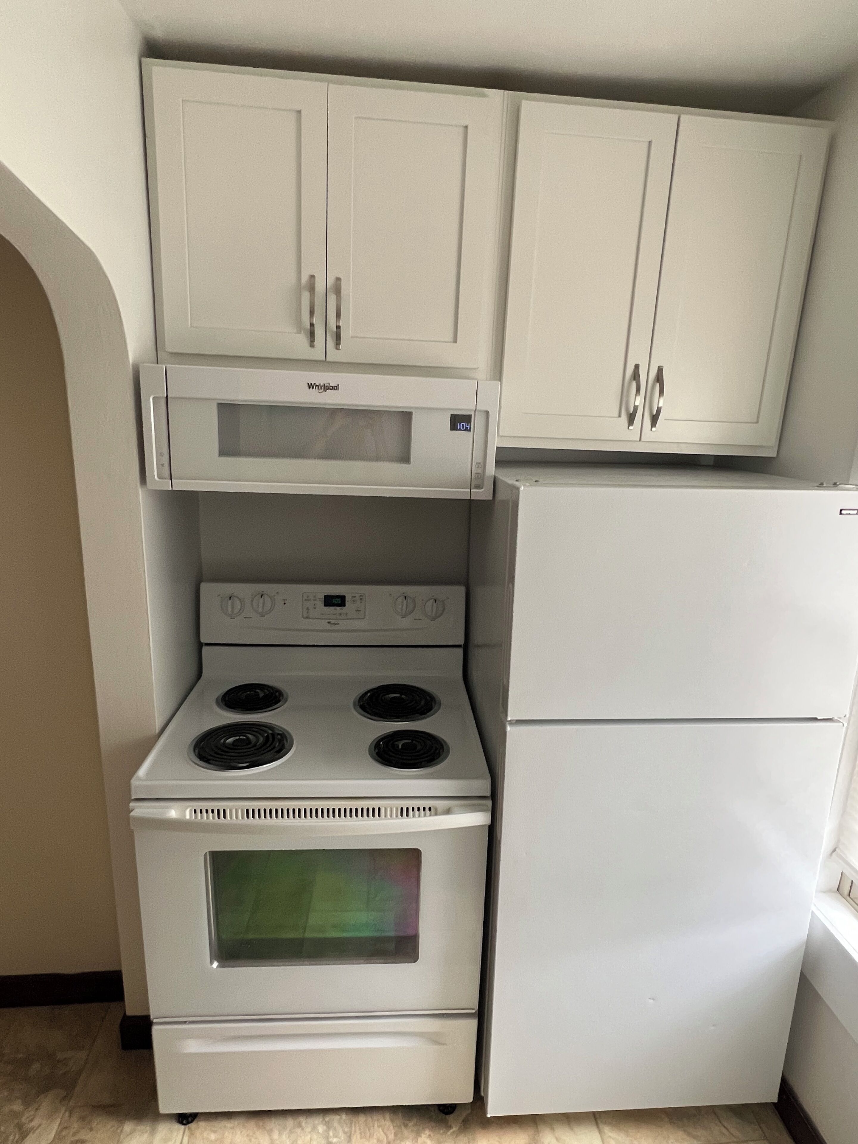 A compact kitchen with a built-in microwave, stove, and refrigerator.