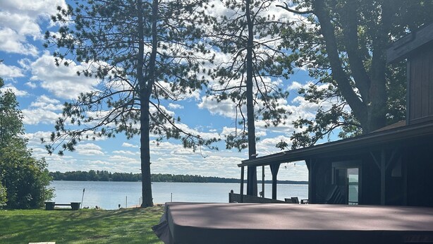 A deck with a view of a lake and trees.