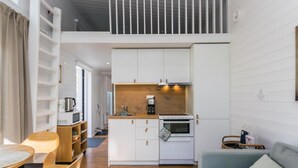A compact kitchen with white cabinets, a wooden countertop, and a built-in oven. - Villa sirius 56 by Interhome (Kemiönsaari)