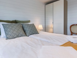 A hotel room with a bed, pillows, a nightstand, a lamp, and a chair. - Villa mimosa 37 by Interhome (Kemiönsaari)