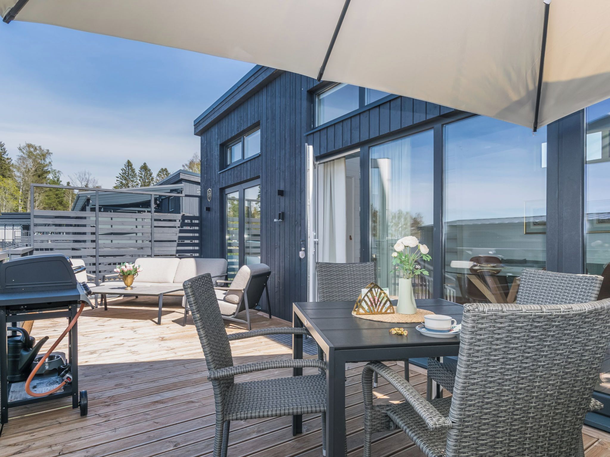 Eine Terrasse im Freien mit Essbereich, Stühlen und Grill.