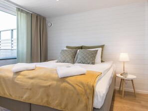 A hotel room with a bed, a bedside table with a lamp, and a view of the outside. - Villa mimosa 37 by Interhome (Kemiönsaari)