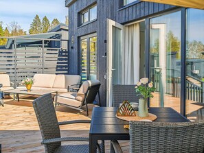 A modern outdoor seating area with a table, chairs, and a potted plant. - Villa mimosa 37 by Interhome (Kemiönsaari)