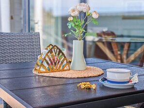 A table with a vase of flowers, a decorative metal piece, and a plate with a bowl.
