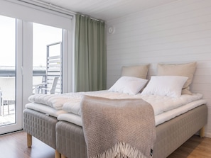 A bedroom with a bed, a chair, a window, and a view of the outside. - Villa otava 15 by Interhome (Kemiönsaari)