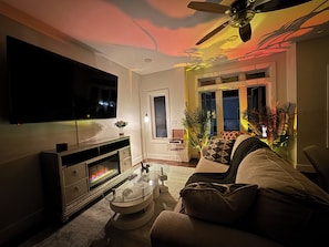 TV connectée, cheminée, livres, chaîne hi-fi