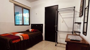 A room with two beds, a window, a door, a radiator, and a small wooden cabinet. - Habitación Independiente al Norte de Mérida (Mérida)