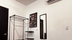 A room with a metal drying rack, a wooden cabinet, a mirror, and a trash bin. - Habitación Independiente al Norte de Mérida (Mérida)