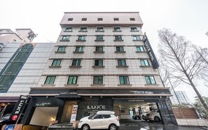 A multi-story hotel building with a modern facade, a visible entrance, and a parking area. - Nowon Luxe hotel (Seoul)