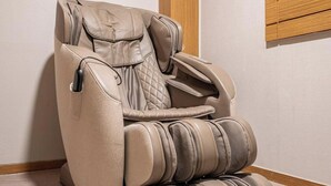 A massage chair with a padded seat and backrest, armrests, and footrest. - Nowon Luxe hotel (Seoul)