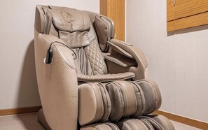 A massage chair with a padded seat and backrest, armrests, and footrest. - Nowon Luxe hotel (Seoul)