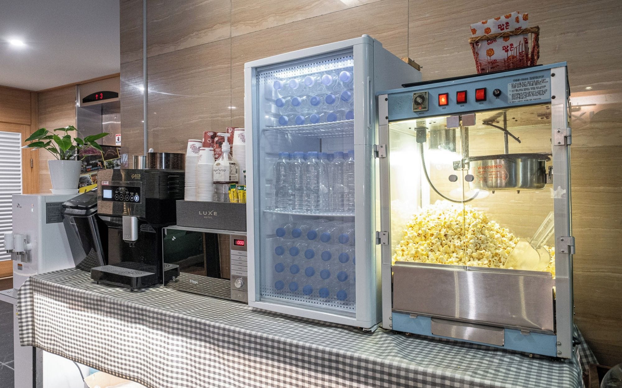 Un distributore automatico per bevande, con una macchina per popcorn, una macchina per caffè e un forno a microonde.