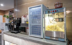 A self-service beverage dispenser with a popcorn machine, a coffee machine, and a microwave. - Nowon Luxe hotel (Seoul)