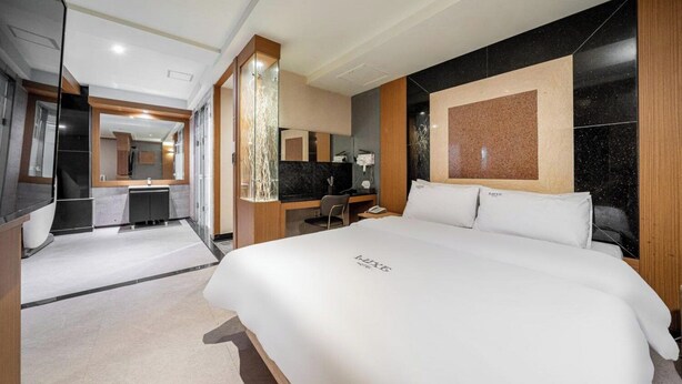 A modern hotel room with a large bed, a desk, and a bathroom. - Nowon Luxe hotel (Seoul)