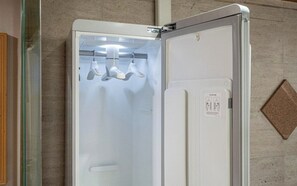A white, wall-mounted refrigerator with a glass door, a control panel, and a warning label. - Nowon Luxe hotel (Seoul)