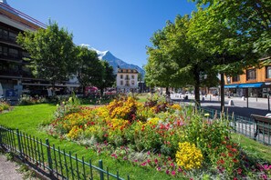 Stroll through a vibrant garden surrounded by a lush variety of flowers and modern architecture.