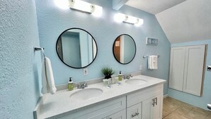 A bathroom with two sinks, a large mirror, and a towel rack. - FLIP FLOP INN, 5MIN TO CRUISE AND BEACH (Galveston)