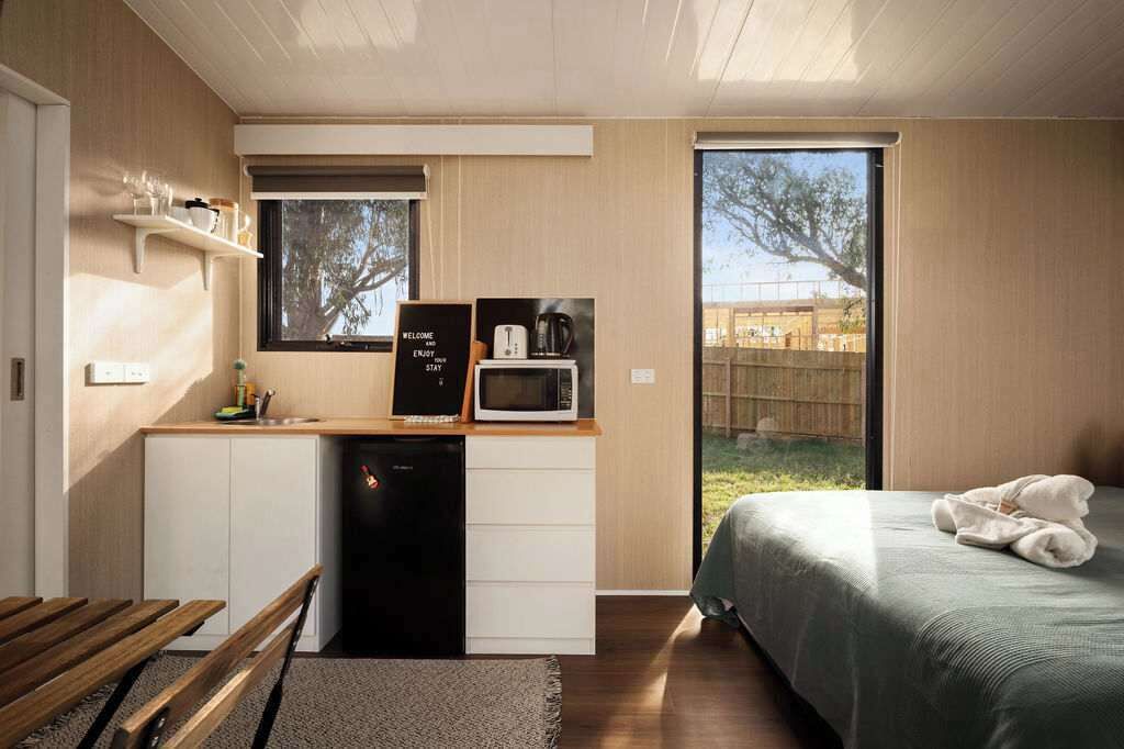 Een compacte kamer met een kitchenette, een bed en uitzicht op de omgeving.
