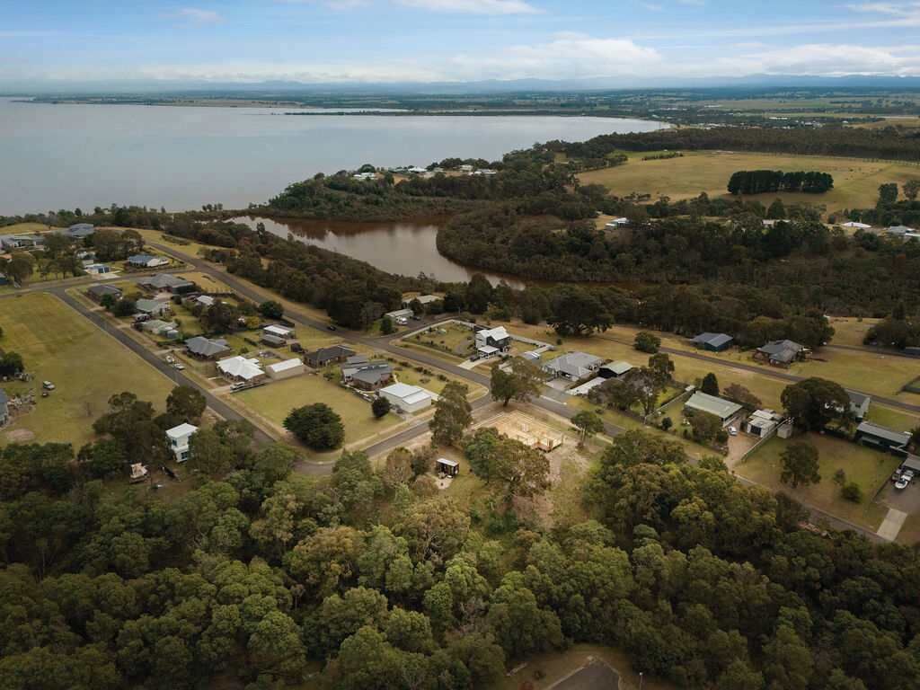 An aerial view of a residential area with houses, roads, and a lake.