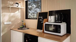 A compact kitchenette with a microwave, coffee maker, and a welcome sign. - Metung Hideaway by Tiny Away (Metung)