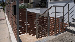 A modern apartment building with a metal staircase and wooden railings. - Warm and colourfull  studio in historical district of Chania (Chania)