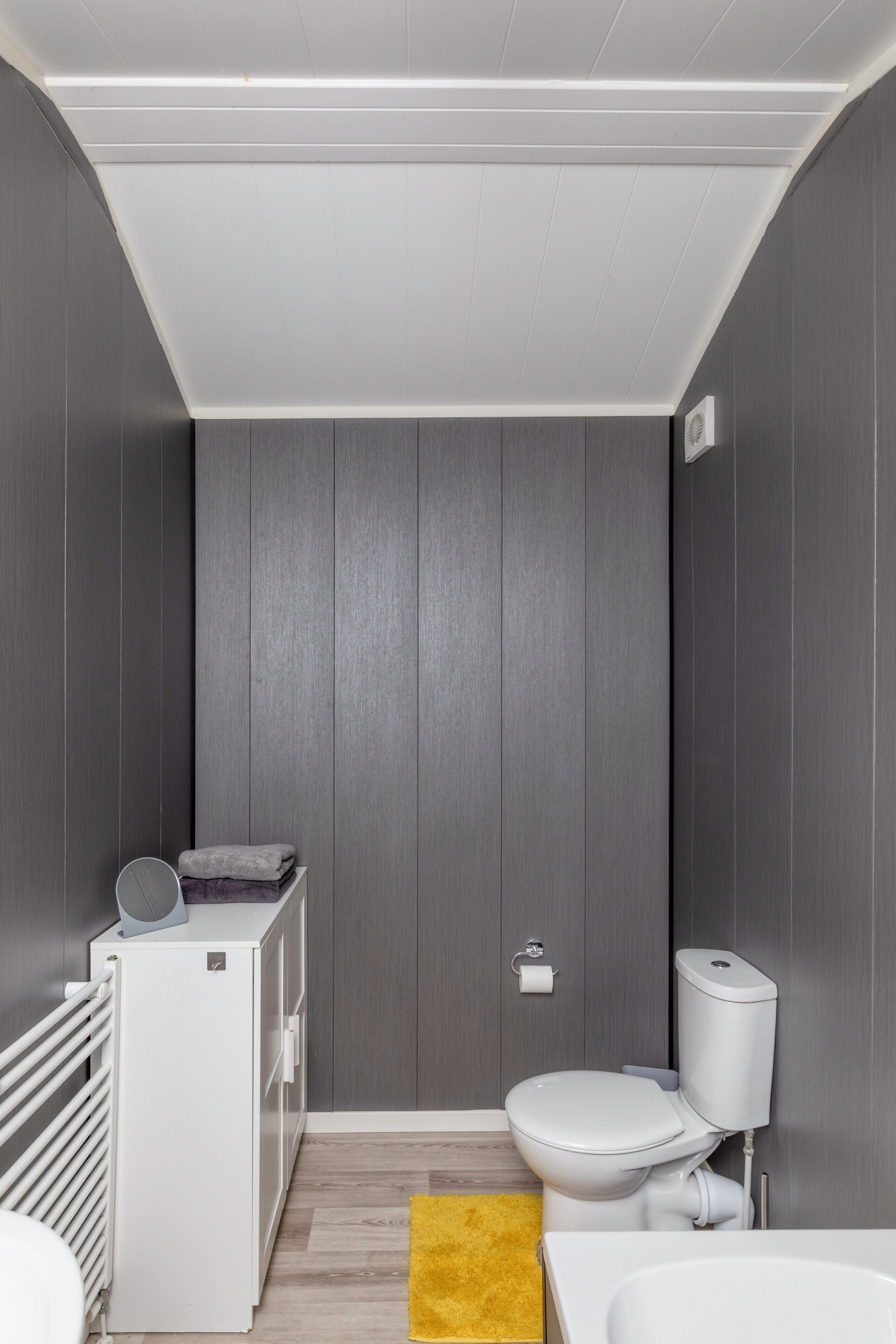 Un baño pequeño con inodoro, bidé y un mueble blanco.