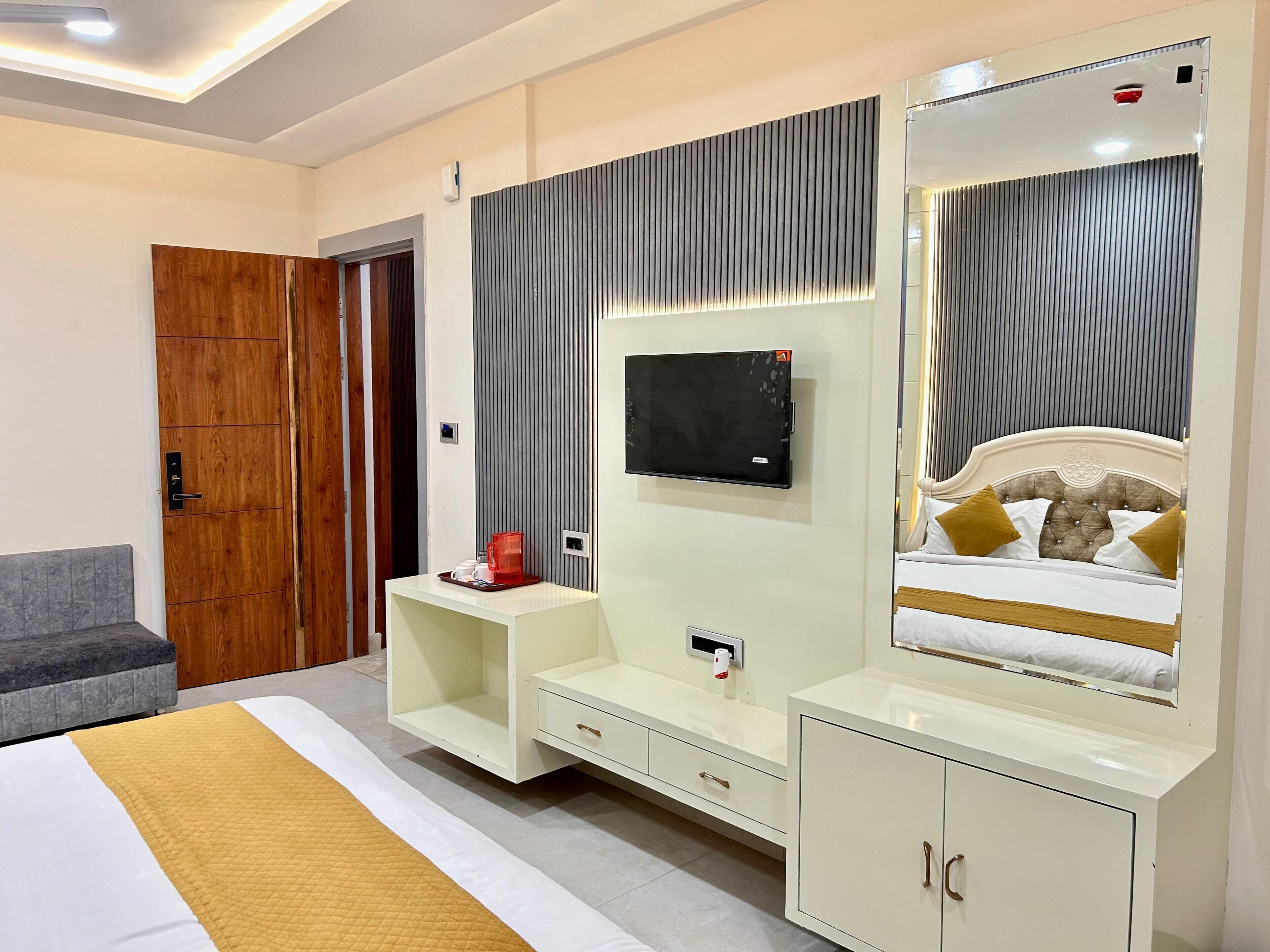 Ein modernes Schlafzimmer mit Bett, Fernseher, Schminktisch und Kleiderschrank.