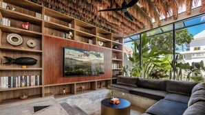 Ein modernes Wohnzimmer mit einem großen Flachbildfernseher, Holzregalen, einem Sofa und einem Couchtisch.