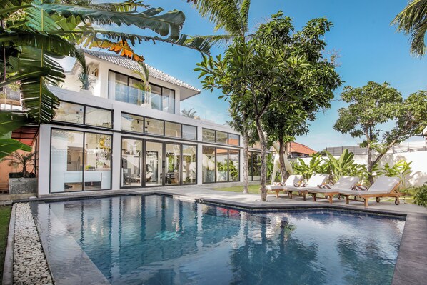 Relax by the well-maintained pool surrounded by lush tropical plants.